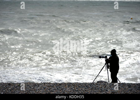Fotografo su una spiaggia in inverno, silhouette non identificabili. Foto Stock