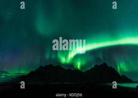 E Stokksnes Vestrahorn con le luci del nord (Aurora Boreale) vicino a Hofn, Islanda Foto Stock