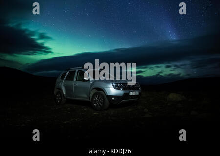 Dacia Duster Noleggio Noleggio auto 4x4 a Aldeyjarfoss con luci del nord (Aurora Boreale) catturati dietro Foto Stock