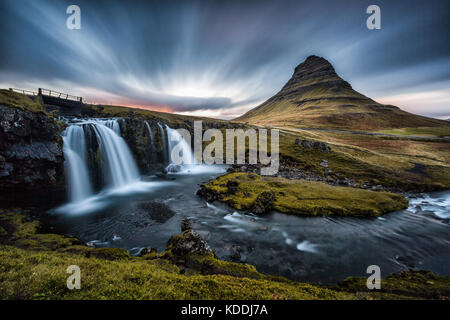 Kirkjufell montagna con Kirkjufellfoss in primo piano con una lunga esposizione al tramonto, Snaefellsnes Peninsula, Islanda Foto Stock