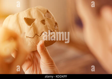 Close-up bella donna artista facendo su una argilla faccia di zucca jack per halloween su una tavola di legno in officina, preparare per la Festa di halloween Foto Stock