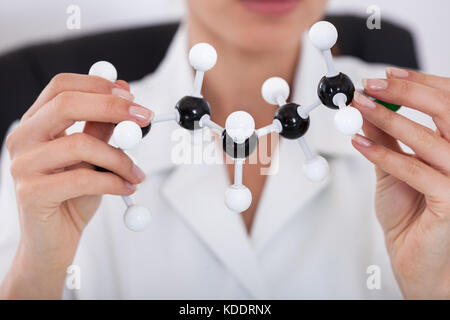 Donna scienziato concentrando sulla struttura molecolare in laboratorio Foto Stock