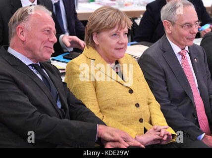 Hannover, Germania. 12 ottobre 2017. La cancelliera tedesca Angela Merkel (CDU) siede accanto al presidente dell'IG BCE, Michael Vassiliadis (R) e Juergen Trittin dei Verdi (L) al congresso sindacale dell'Industriegewerkschaft Bergbau, Chemie, energie (IG BCE) ad Hannover, Germania, 12 ottobre 2017. Credito: Julian Stratenschulte/dpa/Alamy Live News Foto Stock