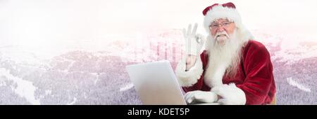 Composito Digitale di Santa Claus in inverno con il computer portatile Foto Stock