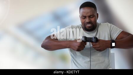 Composito Digitale dell'uomo giocando con il computer controller di gioco con un luminoso sfondo sfocato Foto Stock