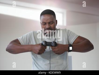 Composito Digitale dell'uomo frustrato giocando con il computer controller di gioco con sfondo luminoso Foto Stock