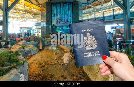 Aeroporto Internazionale di Vancouver - 11 aprile, 2017: a mano in possesso di un passaporto canadese all'aeroporto internazionale di Vancouver lounge Foto Stock