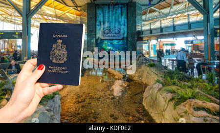 Aeroporto Internazionale di Vancouver - 11 aprile, 2017: a mano in possesso di un passaporto canadese all'aeroporto internazionale di Vancouver lounge Foto Stock