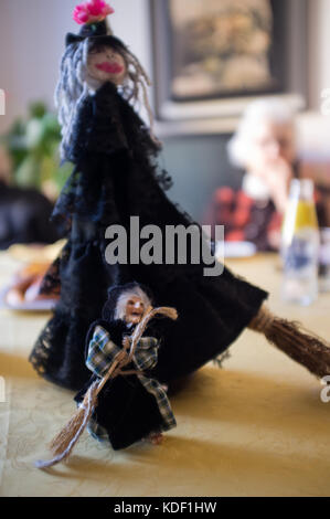 Epifania e Halloween fatti in casa delle bambole felice di stare su una tavola di legno con grande nonna sorridente in background. Firenze, Italia Foto Stock