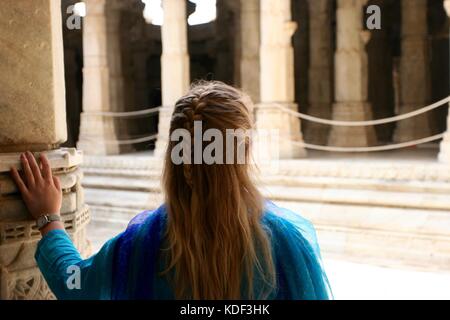 Un turista femminile passeggiate attraverso il Ranakpur Jain Temple in India mentre ammirate l'architettura Foto Stock