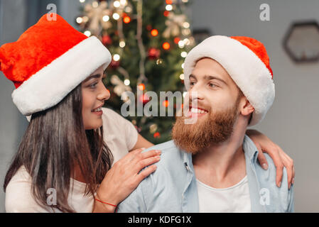 Coppia felice in cappelli di Babbo Natale Foto Stock