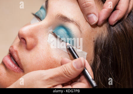 Make up Artist usando del nastro adesivo protettivo per la creazione di occhi di gatto Foto Stock