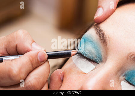 Make up Artist usando del nastro adesivo protettivo per la creazione di occhi di gatto Foto Stock