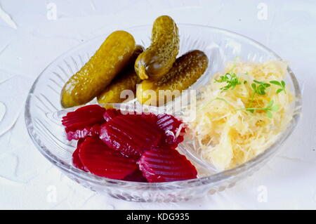 Una sana il pranzo o la cena con sgombro affumicato, cetrioli sottaceto, barbabietole, crauti, patatine fritte su un grigio Sfondo astratto. cibo sano. Cibo Foto Stock