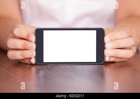 Close-up di donna che mostra il telefono cellulare con schermo vuoto Foto Stock