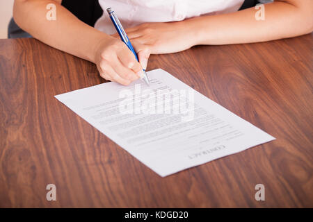 Close-up di femmina firma a mano carta contratto Foto Stock
