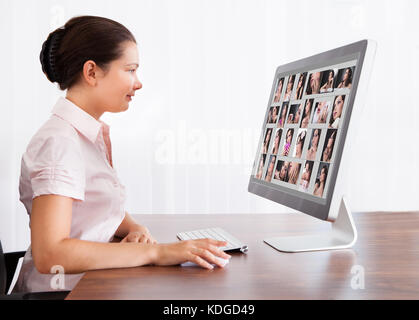 Felice designer professionista donna editing di immagini in office Foto Stock