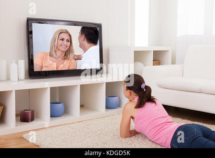 Giovane bella donna in soggiorno a guardare la televisione Foto Stock