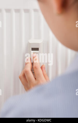 Foto di una donna la regolazione della temperatura con termostato digitale Foto Stock