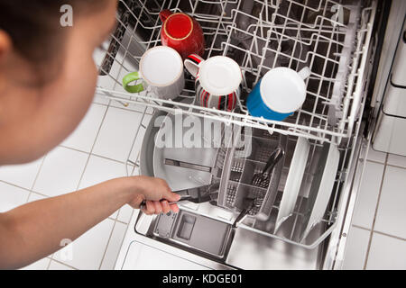 Elevato angolo di visione della donna Posizionamento utensili in lavastoviglie Foto Stock