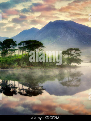 Alba sul loch derryclare/lago con alcuni dei 12 ben montagne. contea di Galway, Connemara, Irlanda Foto Stock