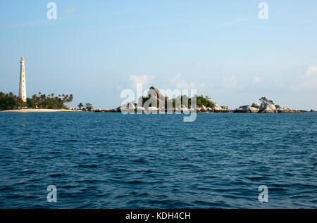 Faro bianco in piedi su un isola in belitung di giorno con n. di persone intorno a. Foto Stock