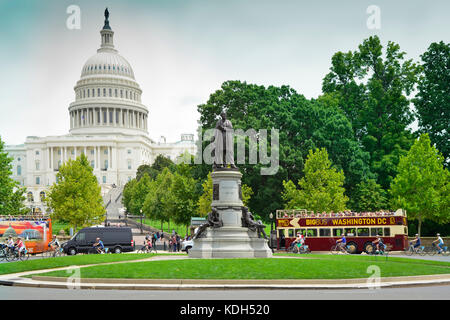 Ciclista e i bus turistici Crociere nel cerchio di fronte a noi il Campidoglio di Washington, DC, Stati Uniti d'America Foto Stock