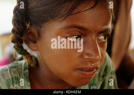 Una giovane ragazza Sindhi prende rifugio dal calore del giorno della sua famiglia houseboat sulle rive del lago di Manchar, Pakistan. Foto Stock