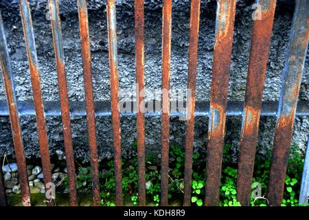 Superficie arrugginito, close-up di un ferro arrugginito griglia appoggiata contro una parete Foto Stock