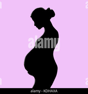 Donna incinta silhouette isolato su sfondo rosa Foto Stock