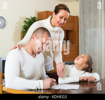 Padre e figlia di rispondere a domande di outreach lavoratore a casa Foto Stock