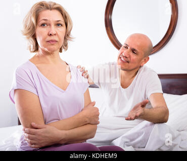 Coppia ragazza consolante addolorate uomo seduto oltre Foto Stock