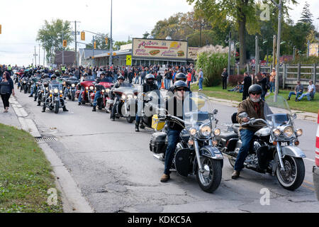 Porto di Dover, Ontario, Canada, 13 ottobre 2017. Migliaia di motociclisti da tutto il Canada e gli Stati Uniti insieme per il venerdì il tredicesimo Raduno motociclistico, che si tiene ogni venerdì il tredicesimo nel porto di Dover, Ontario, Canada, dal 1981. L'evento è uno dei più grandi a singolo giorno motociclo eventi in tutto il mondo. Quest'anno, il clima mite hanno contribuito per un gran numero di motociclisti e curiosi, con centinaia di motociclette personalizzate, fornitori di musica dal vivo e persone interessanti da guardare. Bikers line-up riding essi motocicli in una strada del centro. Credito: Rubens Alarcon/Alamy Live News Foto Stock