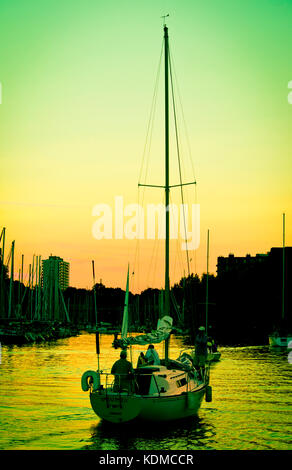 Yacht con vele verso il basso entrando in oakville marina sul lago Ontario Foto Stock