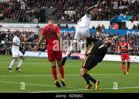 Il Leroy Fer (centro) di Swansea City batte il portiere dell'Huddersfield Town Jonas Lossl durante la partita di Premier League al Liberty Stadium di Swansea. Foto Stock