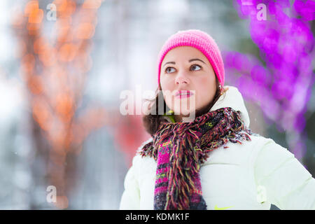 Felice inverno donne nel parco della neve e le luci di Natale Foto Stock