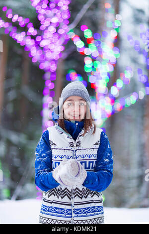 Felice inverno donne nel parco della neve e le luci di Natale Foto Stock