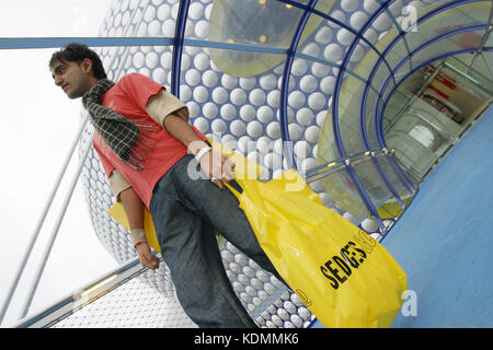 Shoppers lasciare magazzini Selfridges a Birmingham laden con acquisti, 2003. Foto Stock