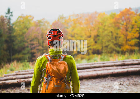 Mountain Biker guardando ispirando paesaggio di montagna, in piedi con la bicicletta. Uomo MTB ciclismo su strada sterrata nel bosco. Sport e ricreazione attiva, fi Foto Stock