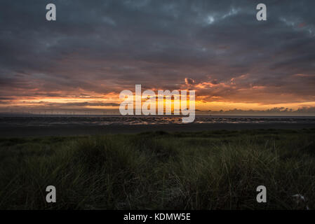 Tramonto da formby beach, Merseyside, guardando fuori attraverso il mare irlandese withwind turbine in distanza Foto Stock