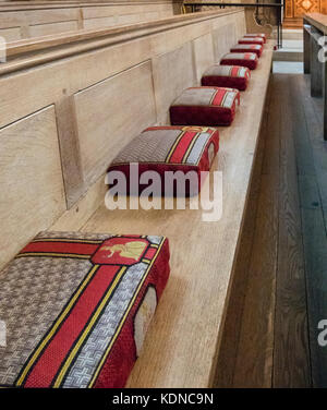 Una fila di preghiera cuscini su un pew nella cattedrale di Norwich, Norfolk, Regno Unito Foto Stock