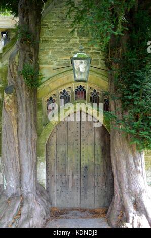 Porta nord fiancheggiata da alberi di tasso, st Edward's chiesa parrocchiale, Stow-su-il-wold, in Cotswolds, Regno Unito Foto Stock