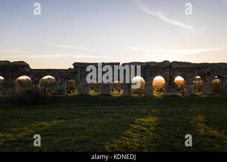 Vista aerea dell antico acquedotto dell'impero romano al tramonto. Le ombre delle arcate dell'acquedotto di stand su un pubblico parco verde. Foto Stock