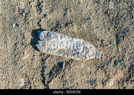 Vecchia bottiglia di plastica sul terreno in natura Foto Stock