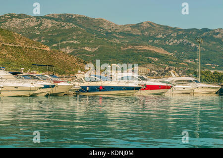 Pontile per barche a vela e barche con una vista delle montagne al largo della costa di Budva, Montenegro. Foto Stock