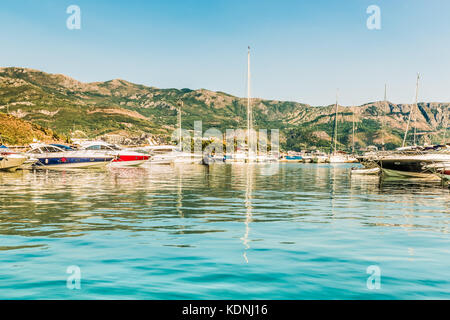 Pontile per barche a vela e barche con una vista delle montagne al largo della costa di Budva, Montenegro. Foto Stock