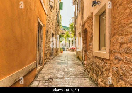 Old town street, Budva Montenegro. La prima menzione di questa città - più di 26 secoli fa. Vediamo case antiche, una strada molto stretta, caffetterie, s Foto Stock