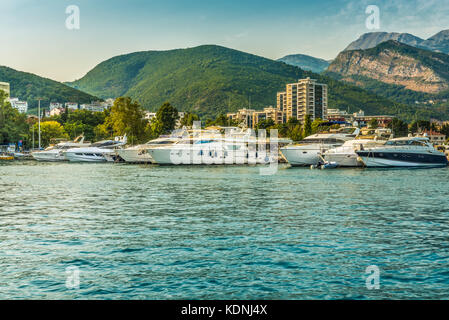 Pontile per barche a vela e barche con una vista delle montagne al largo della costa di Budva, Montenegro. Foto Stock