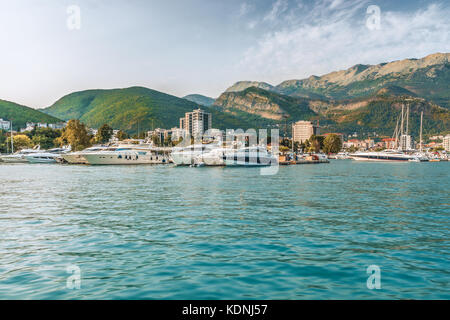 Pontile per barche a vela e barche con una vista delle montagne al largo della costa di Budva, Montenegro. Foto Stock