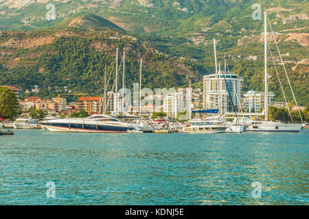 Pontile per barche a vela e barche con una vista delle montagne al largo della costa di Budva, Montenegro. Foto Stock